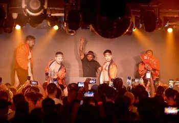 Gay travel destination: DJ and performers entertain a crowd at a gay club. Audience members record the show on their phones.