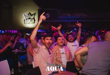 Aqua Club, a gay cruise club in Torremolinos. Cheering crowd at a gay bar. Nightlife scene with men raising their hands in celebration.