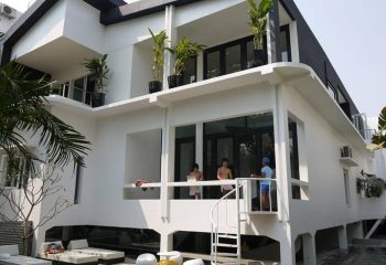 Arthur & Paul men-only hotel: modern white building with a spiral staircase and men on the balcony. Gay travel lodging.