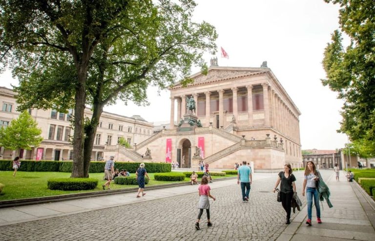 Berlin Uncovered Walking Tour: People stroll near the Altes Museum, a key sight in Berlin. Explore iconic spots on a gay-friendly tour.