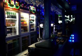 Brief Encounter Gay Bar in Benidorm: Interior view of the bar, showing drinks fridges, bar top, and glassware. Nightlife for gay men travel.