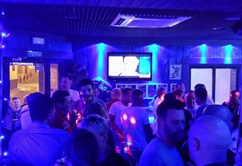 Inside a gay bar in Benidorm, Spain. A crowded space with blue lighting and men socializing. Gay travel advice, Brief Encounter bar.