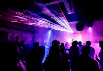 Burdekin Hotel Sydney: Silhouetted crowd dances under vibrant laser lights. Gay nightlife at its best, a must-visit destination.