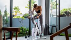 A woman riding one of the best exercise bikes at home