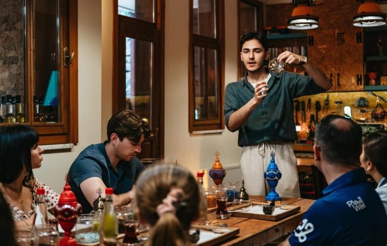 Gay travelers crafting Turkish mosaic lamps in Istanbul. Instructor demonstrates lamp making at a workshop with drinks and art.