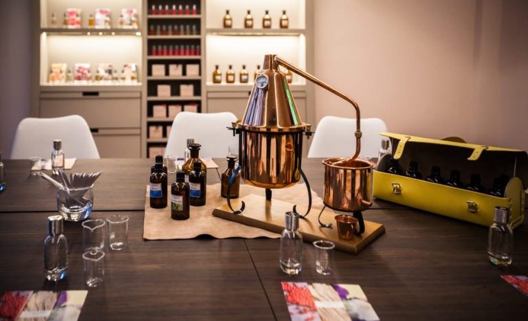 Paris perfume masterclass: Table setting with copper still, bottles, & tools for creating a signature scent. Gay travel experience.