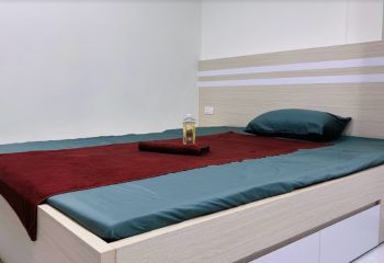 DaNi Spa Hanoi: Massage bed with red towel, oil bottle, and blue sheets. Gay travel advice for relaxation and wellness in Vietnam.