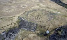 An arial shot of a round divot in a grassy plan, surrounded by excavation quadrants. 