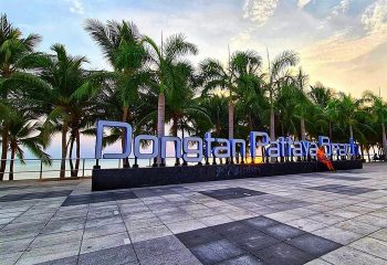 Dongtan Beach Pattaya sign. Tropical gay travel destination. Palm trees, sunset. Popular with gay men. Thailand beach vacation.