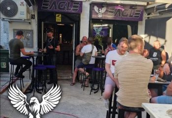Eagle Bar Torremolinos: Gay men gather outside the bar with Eagle signs. A popular gay travel destination in Spain's Costa del Sol.