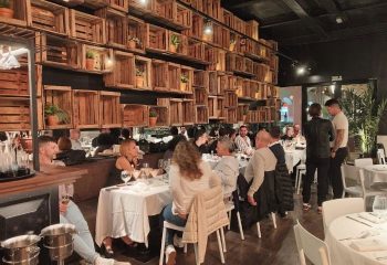 El Gato Lounge gay bar in Torremolinos, Spain. Interior view of the restaurant with people dining. Stylish decor with wooden crates on the wall.