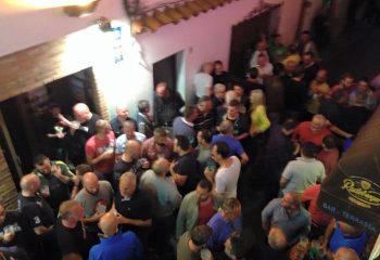 Busy El Horno Gay Bar in Sitges. A crowd of gay men are enjoying drinks and socializing at this popular gay travel destination.