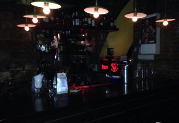 El Horno Gay Bar in Sitges. Interior shot of the bar with bottles, glasses, and a Jägermeister sign. Gay travel advice.
