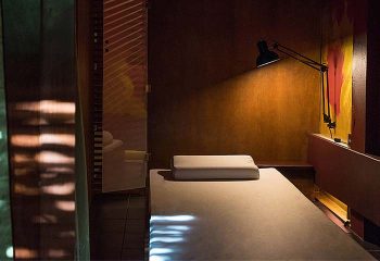 Emerald Green Mens Club, Samui: Interior of a spa room, bed with pillow, and lamp. Gay travel advice for men in Thailand.