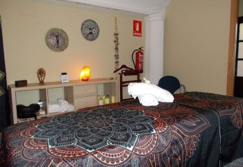 Massage table at Maspalomas gay massage in Gran Canaria. Relaxing spa interior with towels, salt lamp, and decorative wall art.