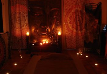Relaxing gay massage setting in Maspalomas, Gran Canaria. Buddha statue, candles, and soft lighting create a sensual, spa-like atmosphere.