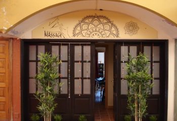 Entrance to Esku Massage in Maspalomas, Gran Canaria. A gay massage place featuring bamboo plants and a mandala design above the door.