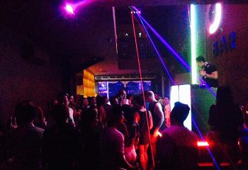 F Bar Bali, popular gay bar in Seminyak's gayborhood. Live DJ, laser lights, and a crowd of people enjoying the vibrant nightlife.