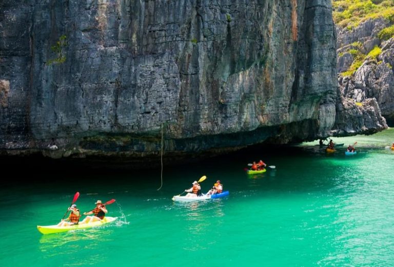 Gay travelers kayaking Ang Thong Marine Park, Thailand. Full-day adventure: snorkeling, limestone cliffs, clear turquoise water.