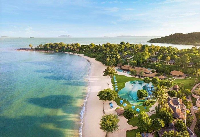 Aerial view of The Naka Island, a Luxury Collection Resort & Spa, Phuket. Gay-friendly hotel with beach, pool, and lush tropical landscape.