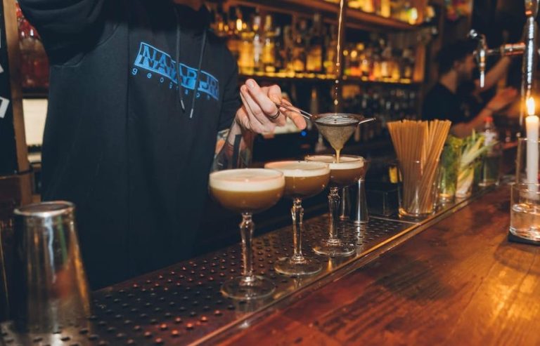 Bartender pours cocktails at a gay-friendly bar in Budapest. Enjoy a tipsy bar crawl, dance, and discover with a local guide.
