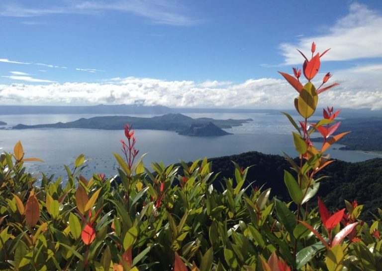Taal Volcano view from Manila, Philippines. Gay travel to Pagsanjan Falls escape. Lush foliage frames the scenic landscape.