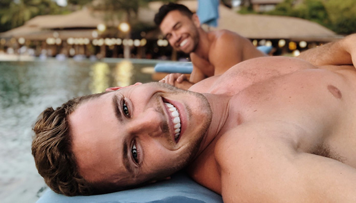 Gay Phuket luxury hotels: Two shirtless men smiling poolside. A tropical getaway for gay men's travel advice.