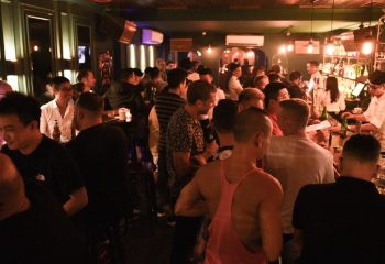 Crowded gay bar in Hanoi. Men socializing, drinking at the bar. Nightlife scene. Gay travel in Vietnam. GC Bar, a popular gay venue.