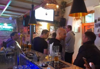 Habrolo Cafe Bar Budapest interior. Gay bar scene with men at the counter. Budapest gay travel advice, gay nightlife, and gay bar scene.