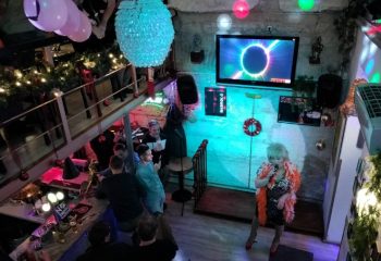 Habrolo Cafe Bar Budapest: Drag queen performing at the gay bar. Men gather at the bar in this popular Budapest gay travel destination.