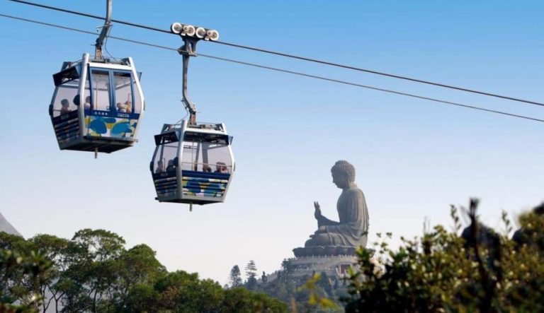 Hong Kong adventure: Lantau Island's Big Buddha statue view from a cable car. A must-see on a gay-friendly trip. Dolphin cruise nearby.