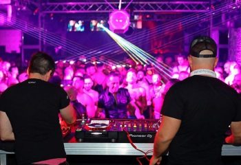 DJs at Into The Tank gay club in Madrid. Men dance under laser lights. Gay nightlife travel advice. Madrid's gay scene.