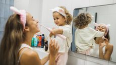 A child brushing their teeth with an electric toothbrush