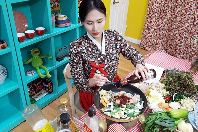 Korea Cooking Class: Woman in Hanbok adds sauce to Korean dish. Seoul e-bike tour alternative: culinary experience. Gay travel advice.