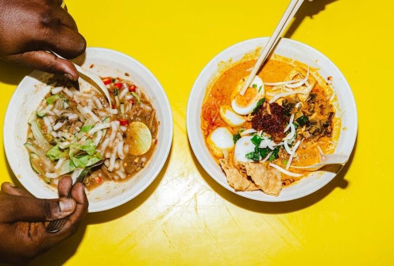 Kuala Lumpur Street Food Feast. Two bowls of Malaysian street food, one with noodles and lime, the other with egg and spices, for gay travelers.