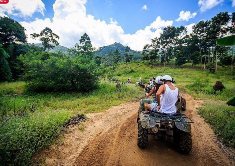 Gay ATV Quad Safari Adventure in Koh Samui. Group of people on ATVs driving through a jungle landscape. Outdoor adventure activity.