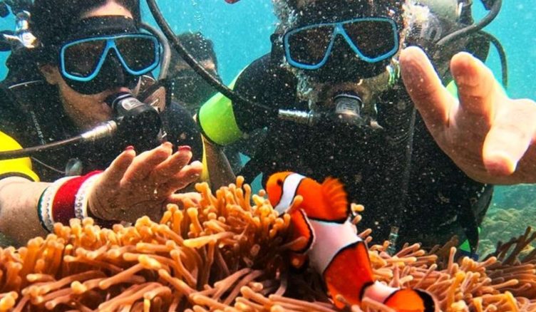 Gay scuba divers snorkeling in Maithon Private Island, Thailand. Luxe scuba escape with Nemo fish and coral reef. Gay travel adventure.