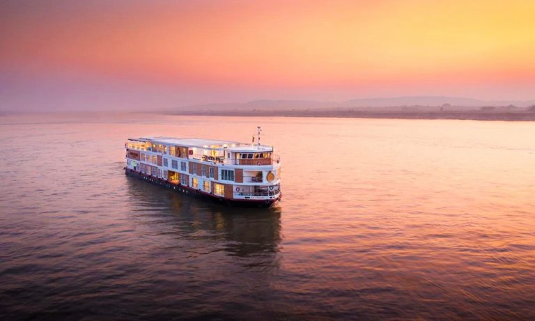 The Strand Cruise ship on the Irrawaddy River at sunset. A luxury gay-friendly cruise from Bagan to Mandalay in Myanmar. River cruise travel.