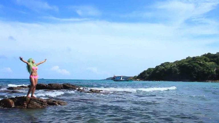 Gay travel: Woman in bikini on rocks by sea. Maxresdefault: beach vacation, island, blue sky. Travel advice for gay men.