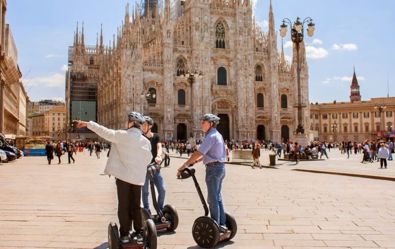 Milan by Segway: Glide through history and high fashion. Men on Segways tour Milan's Piazza del Duomo, sightseeing in style.