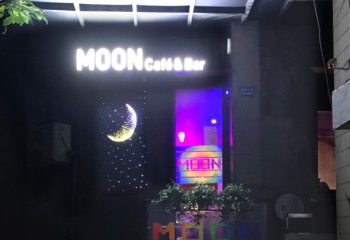 Moon Bar Shanghai, a gay-friendly travel destination, features a neon crescent moon and stars, plus vibrant lights. Nightlife spot.