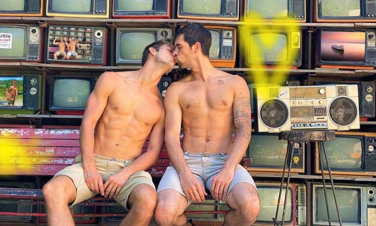 Gay honeymoon trip to Thailand: Max and Andres kissing. Retro TV wall and boombox in background. Gay travel advice.