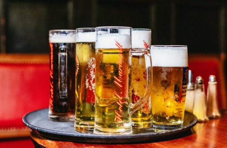 Munich Beer Crawl: Tray of Bavarian beers, including Hofbrauhaus, perfect for gay men's travel. Enjoy breweries & bites in Germany.