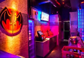 Inside a Mykonos gay club in Gran Canaria. Bar area with Bacardi logo, drinks, and colorful lighting for gay nightlife.