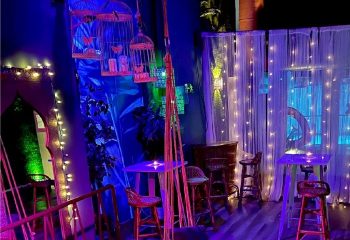 Interior of NKD Spa, a gay cruise club in Madrid. Tables, chairs, birdcages, and fairy lights create a unique ambiance for gay men's travel.