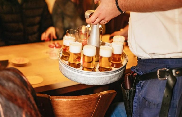 Kölsch beer tray, a Cologne (Köln) Old Town tradition. Bartender serving the beer. Gay travel advice, beer crawl, sip, savor, and explore.