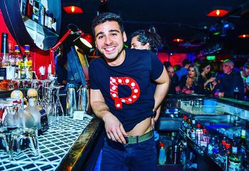 Pantibar, Dublin's best gay bar. Smiling man in Pantibar T-shirt at the bar. Gay Dublin travel guide, nightlife, and gay scene.