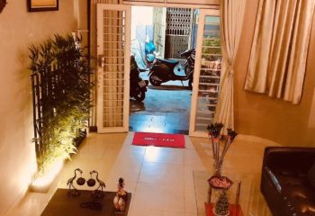 Paradise Spa, Ho Chi Minh City entrance. Open door, Welcome mat, plants, and scooter visible. Gay travel in Vietnam.