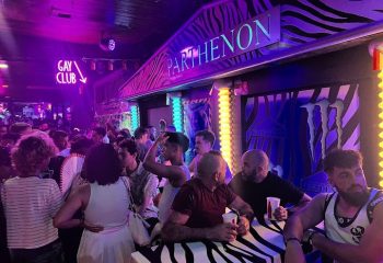 Inside the Parthenon Gay Cruise Club in Torremolinos. Zebra print bar, neon lights, and a crowd of gay men enjoying the night.