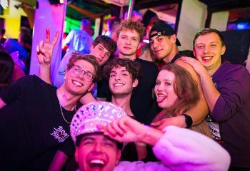 Gay nightlife in Frankfurt: Group of friends smiling at PINK, a popular gay bar. Gay travel advice for Frankfurt, Germany.